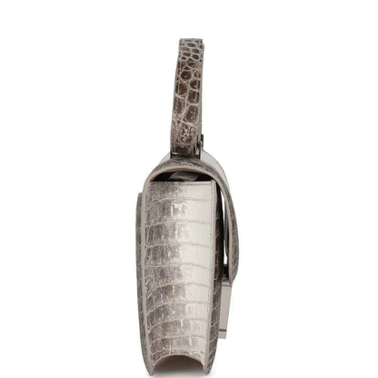 Side view of Constance-style croc-embossed leather bag with flap and turn-lock detail