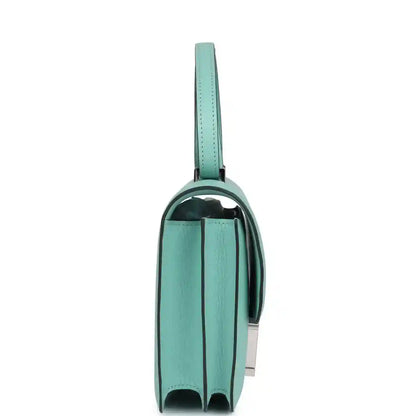 Aqua leather mini handbag side view with strap, stitched edges, and panel seams