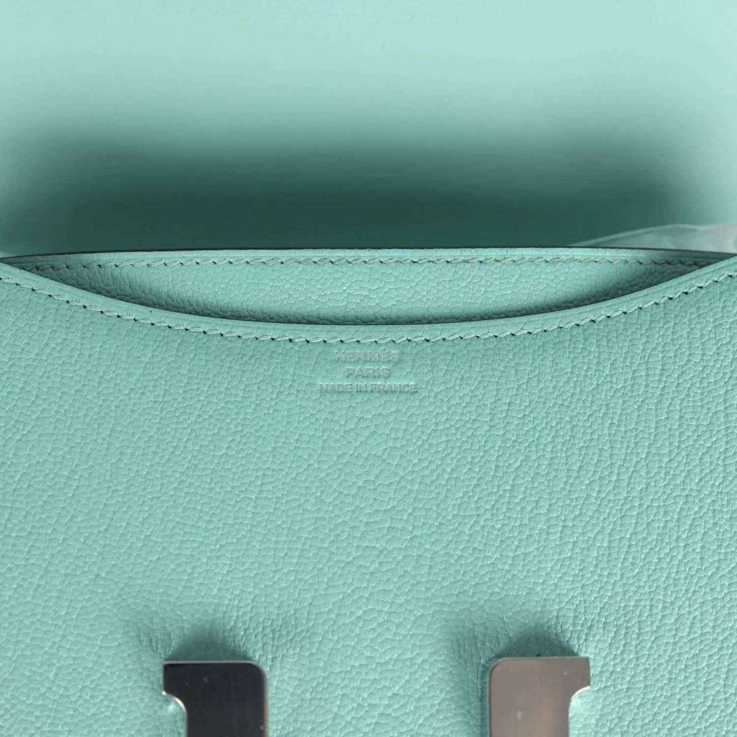 Aqua leather interior lining with curved seams and stitched top edge