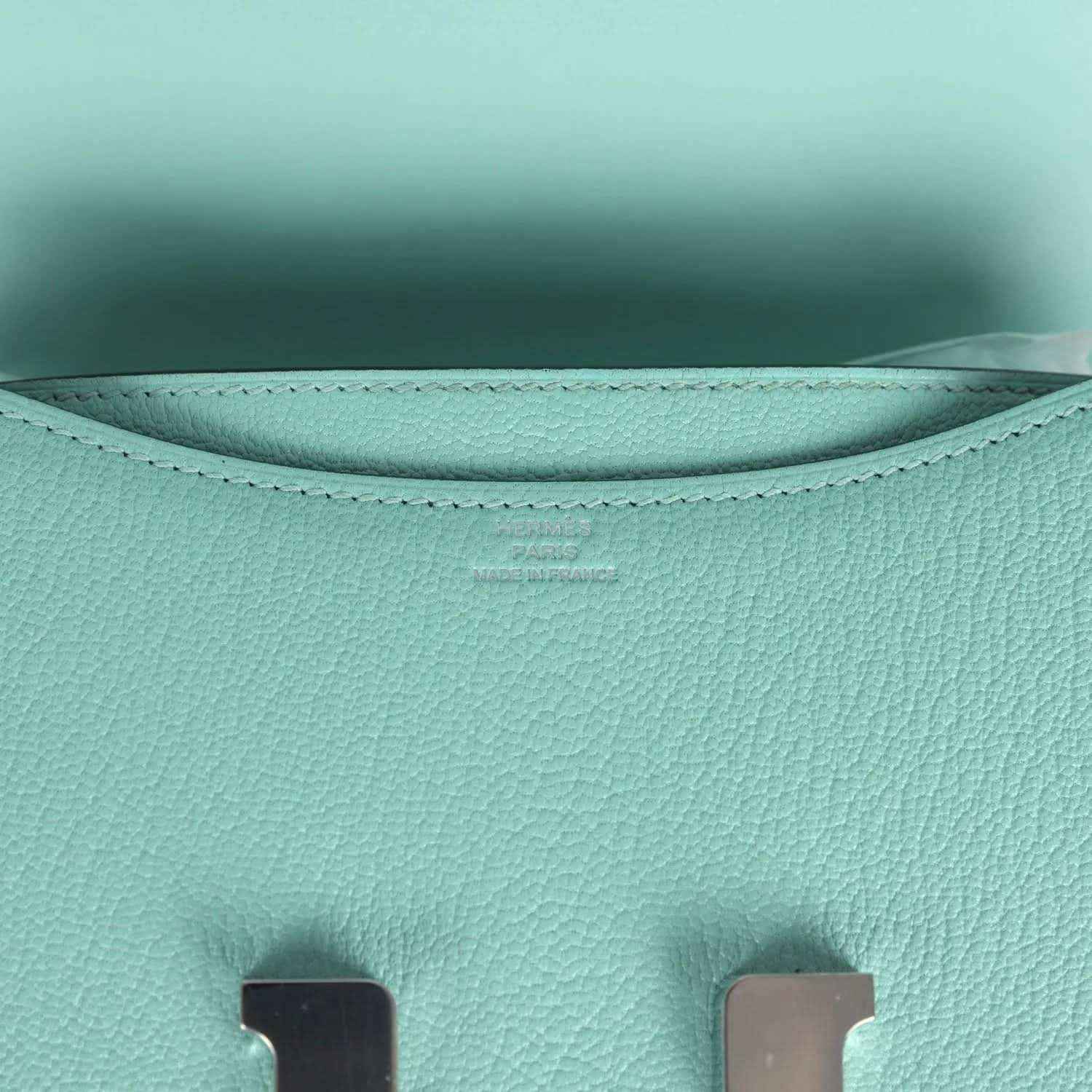 Aqua leather interior lining with curved seams and stitched top edge