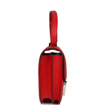 Red leather mini handbag side view with flap edge and strap