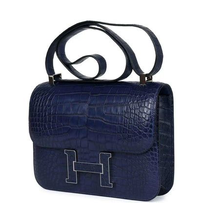 Blue alligator-effect handbag with top handle and front flap with H clasp