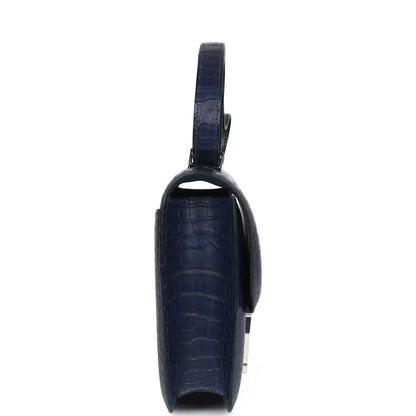 Blue alligator-effect handbag side view with top handle and hinged profile