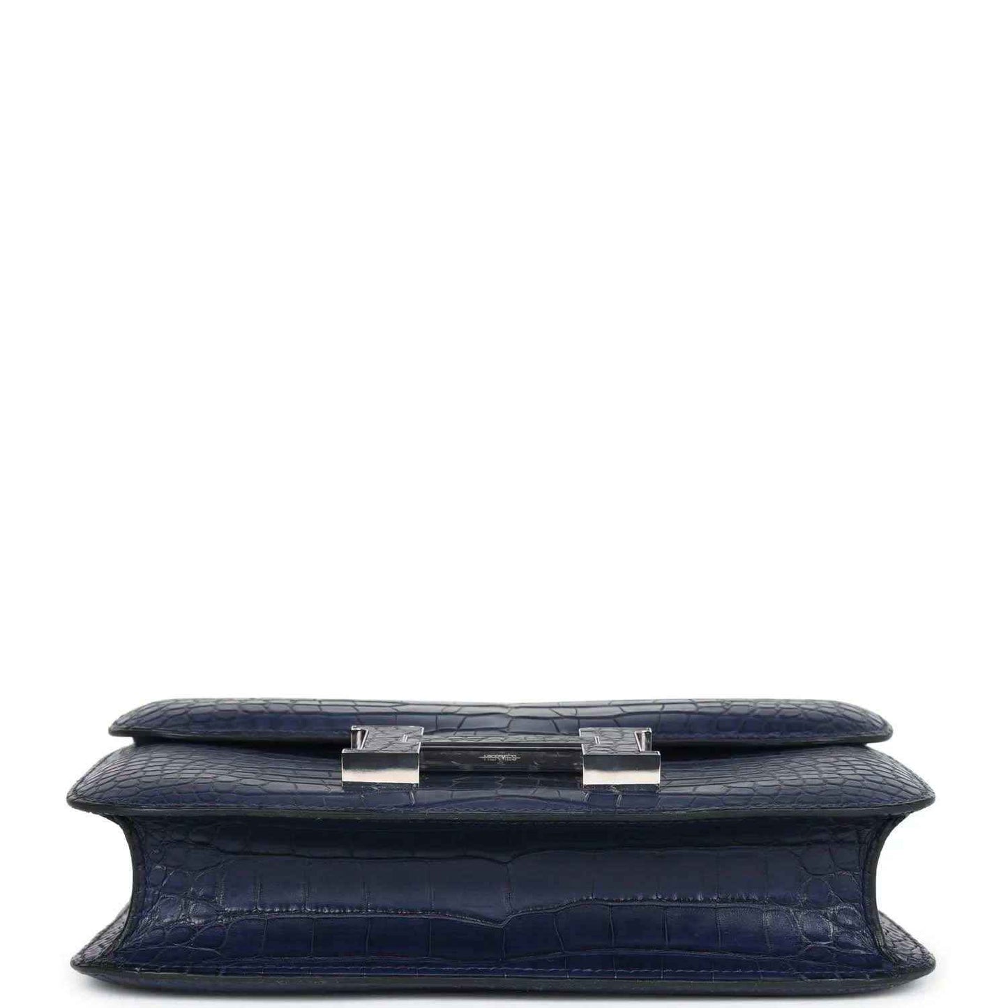 Blue alligator-effect handbag underside with side tab hardware and flat base
