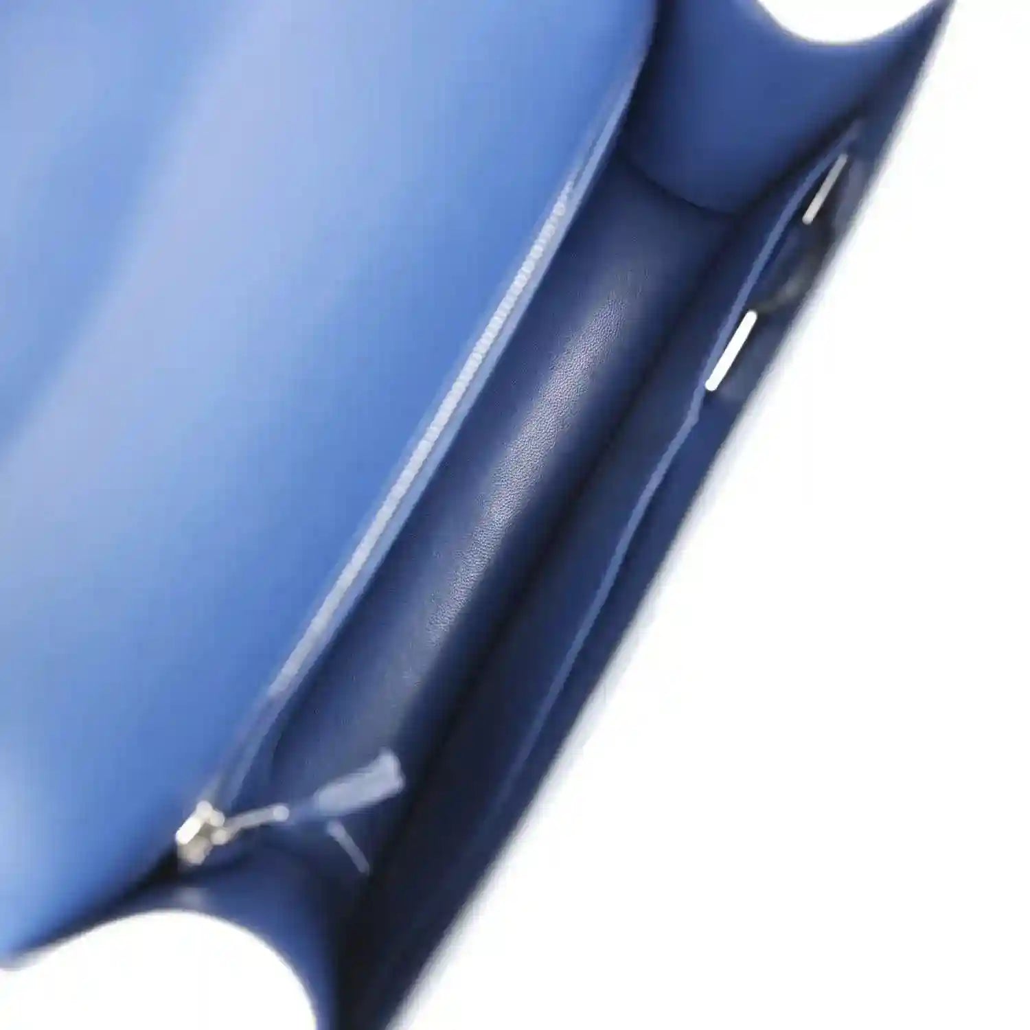 Blue leather-lined handbag interior with side seam and strap hardware