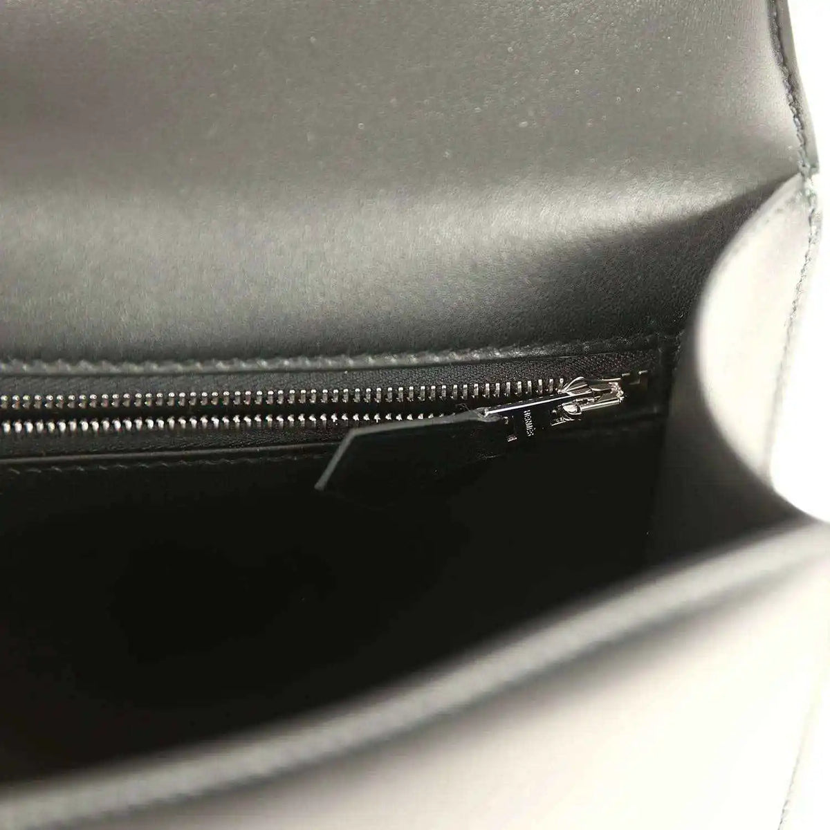 Black leather bag interior with metal zipper and stitched seam