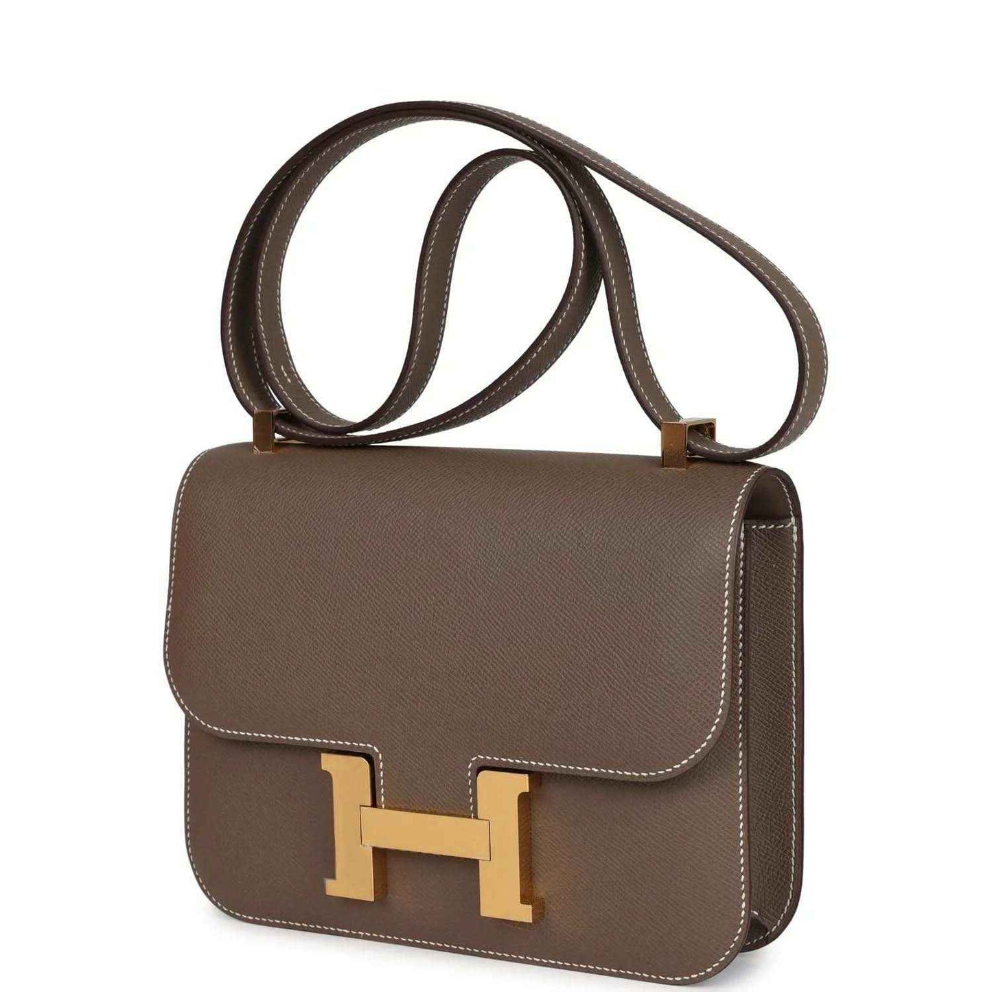 Taupe leather shoulder bag with gold H clasp, curved flap, and hanging shoulder straps