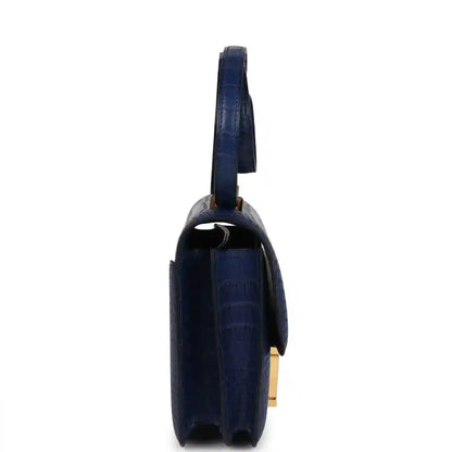 Blue alligator-style bag side view with gold hardware and structured flap