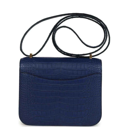 Blue alligator-style flap bag with top handle strap, front clasp not shown