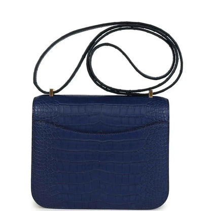 Blue alligator-style flap bag with top handle strap, front clasp not shown
