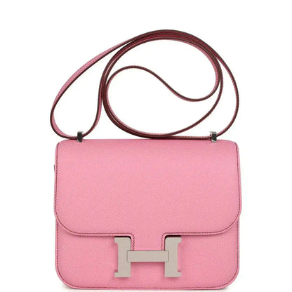 Pink leather crossbody bag with flap, H clasp, and top handle strap