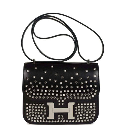 Black studded leather shoulder bag with long strap and metal H clasp