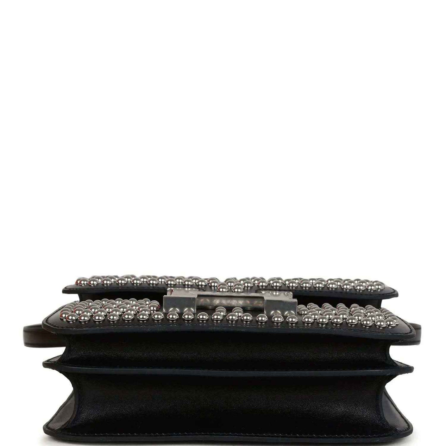 Black leather bag close-up of front flap, studded trim and riveted edge