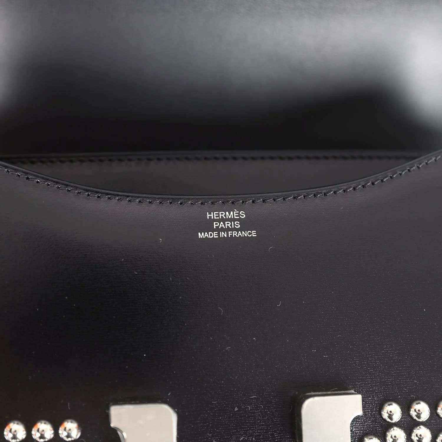 Black leather interior panel with stitched edge and stamped brand text