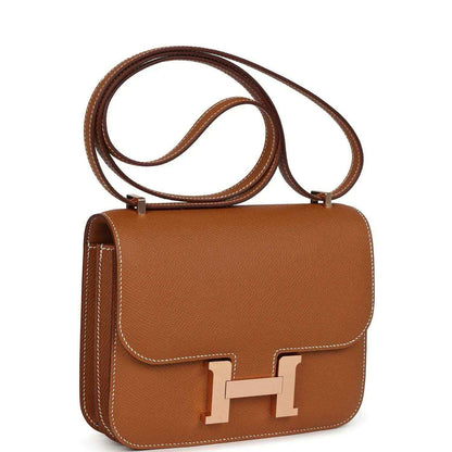 Brown leather mini handbag with crossbody strap and front flap H clasp