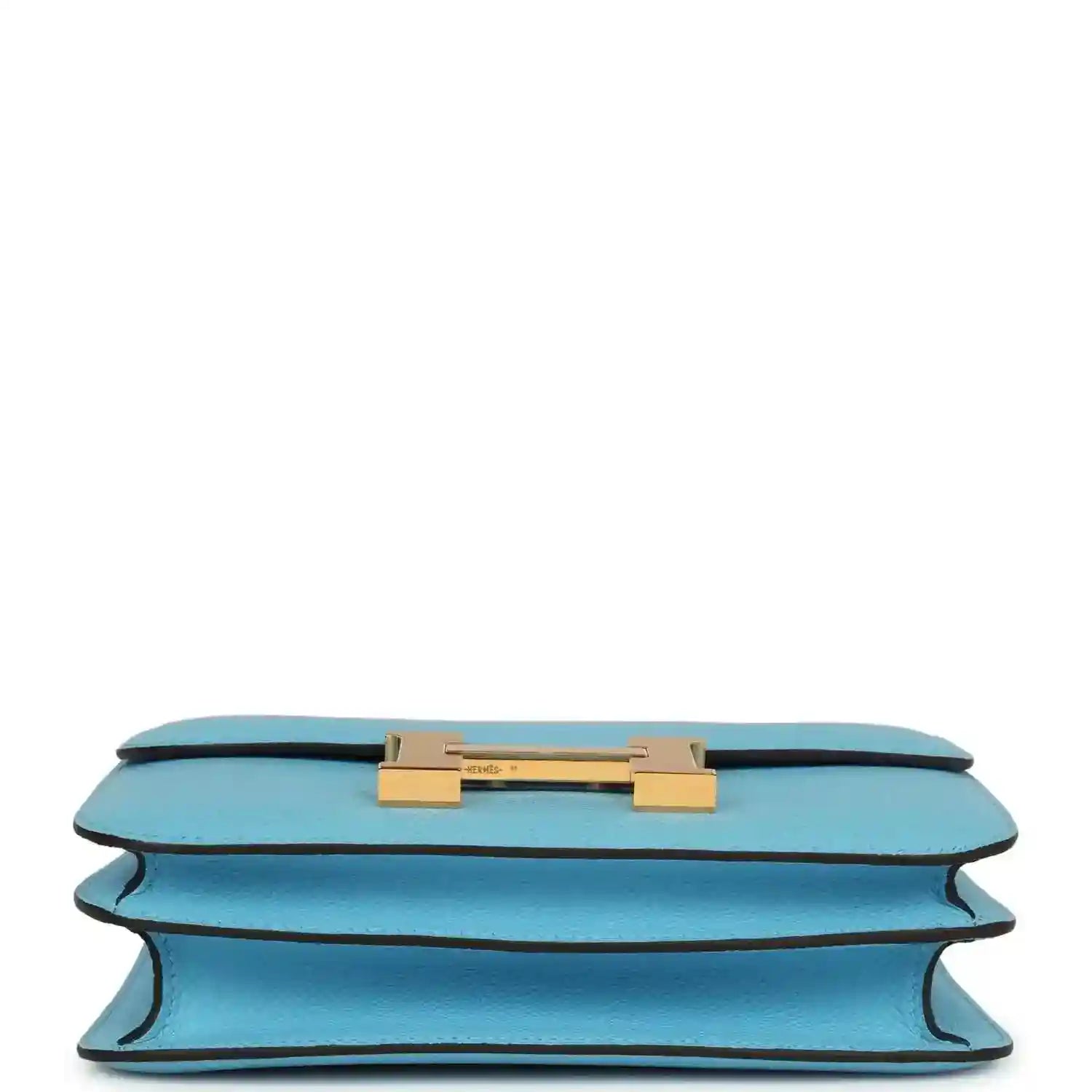 Mini crossbody bag in light blue leather shown from underside with gold hardware bar