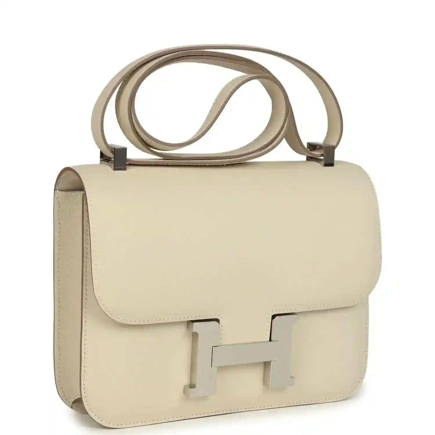 Beige leather handbag with front flap and light silver turn-lock clasp, top handle