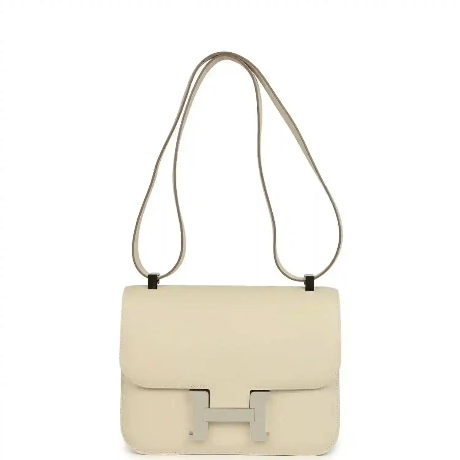 Beige leather shoulder handbag with flap and light silver clasp, long strap