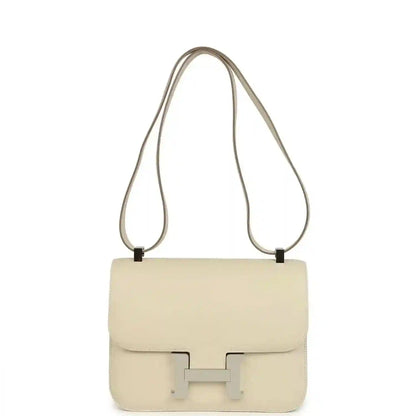 Beige leather shoulder handbag with flap and light silver clasp, long strap