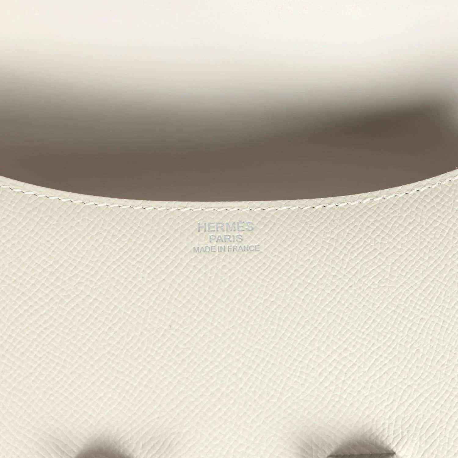 Close-up of beige textured leather handbag interior lining with embossed brand mark