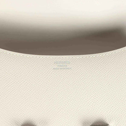 Close-up of beige textured leather handbag interior lining with embossed brand mark