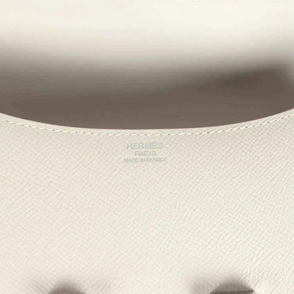 Close-up of beige textured leather handbag interior lining with embossed brand mark