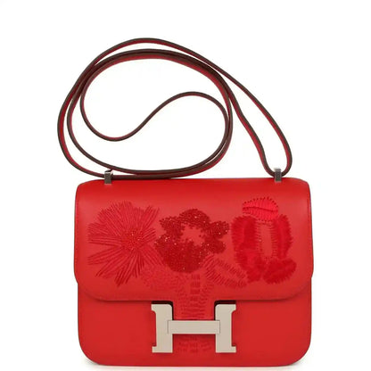Red leather shoulder bag with floral embossed flap and silver H clasp, with double strap
