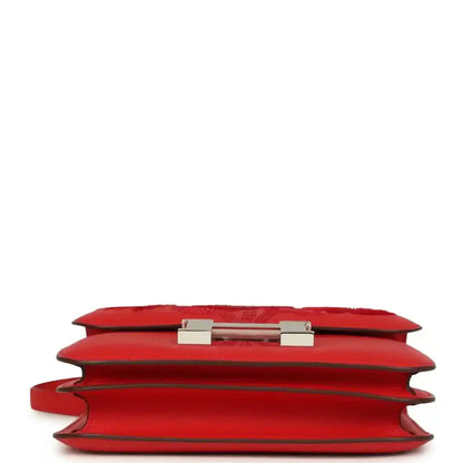Red leather bag side profile with visible hinge hardware on the flap
