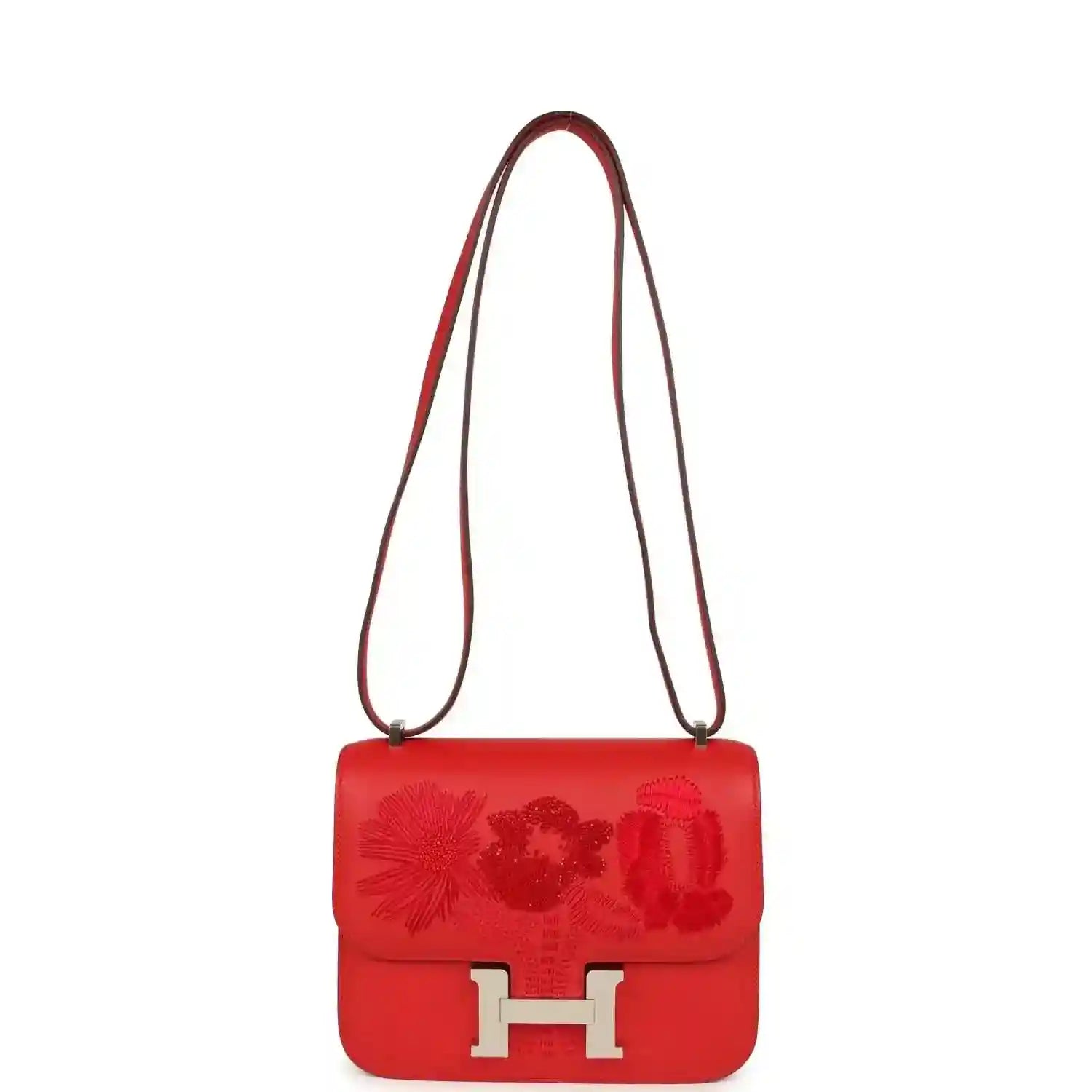 Red leather shoulder bag with embossed floral flap and silver H clasp, long strap