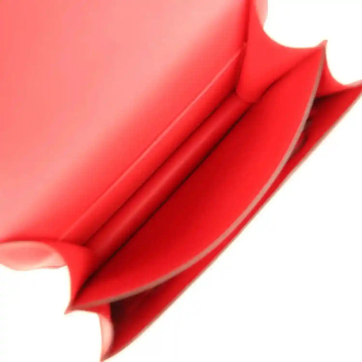 Red leather bag interior close-up with folded lining and seam detail
