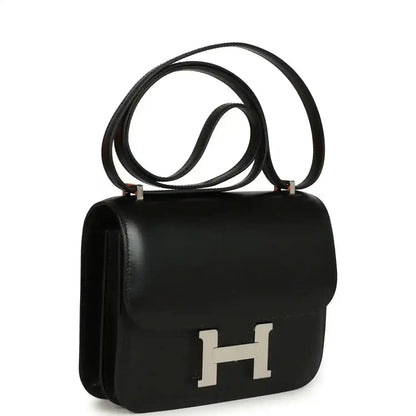 Black calfskin shoulder bag with front flap and H clasp, top handle and long strap.