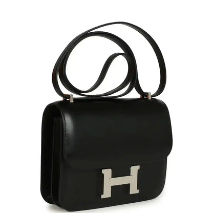Black calfskin shoulder bag with front flap and H clasp, top handle and long strap.