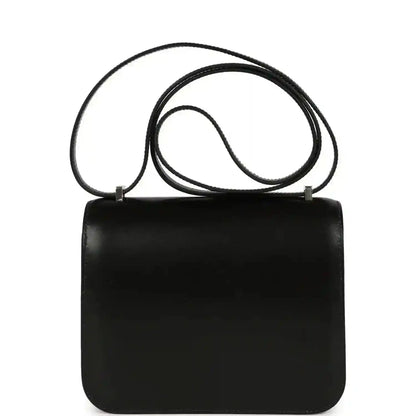 Black calfskin top-handle bag with front flap and H clasp; long shoulder strap attached.