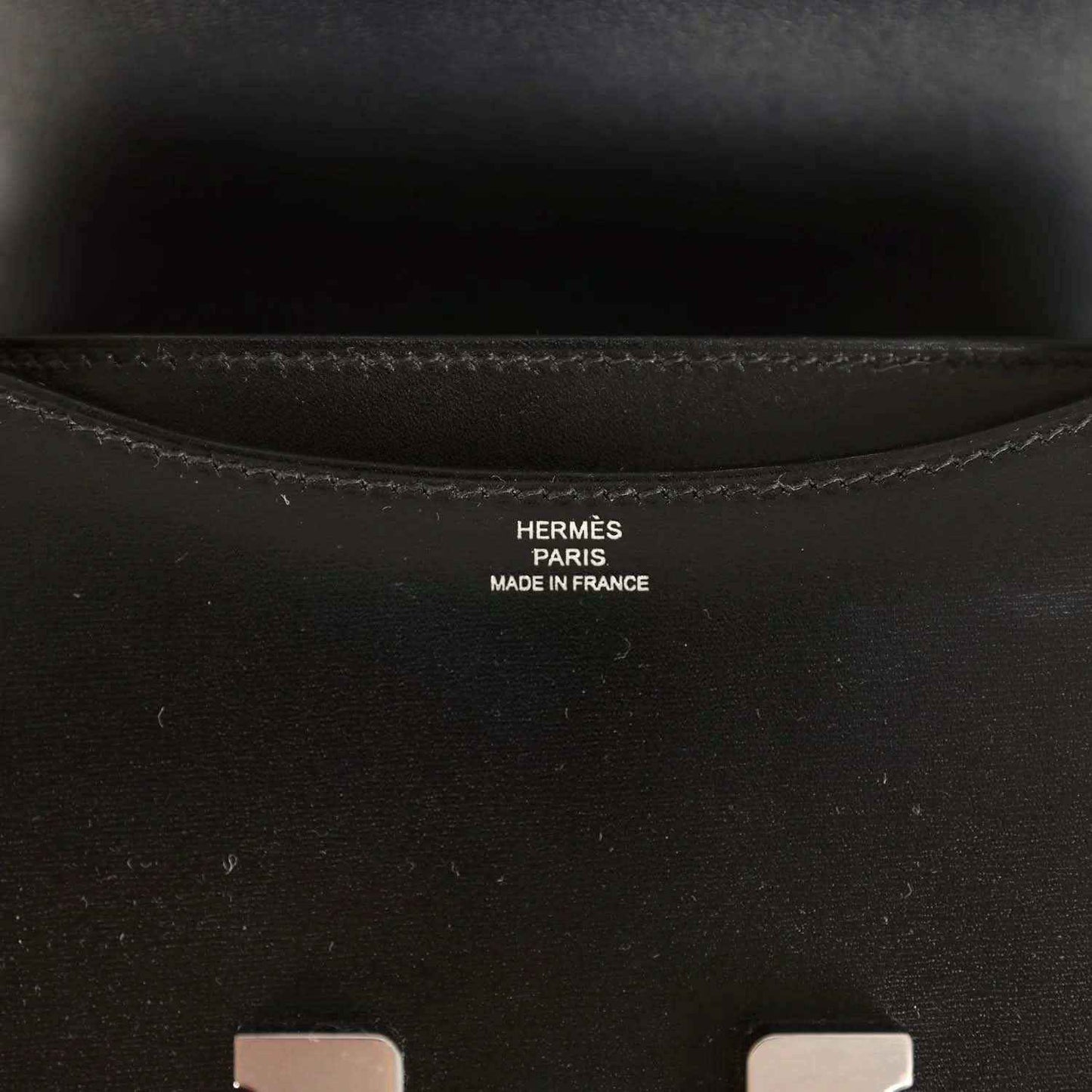 Hermes Paris made in France stamp inside black calfskin bag near seam stitching.