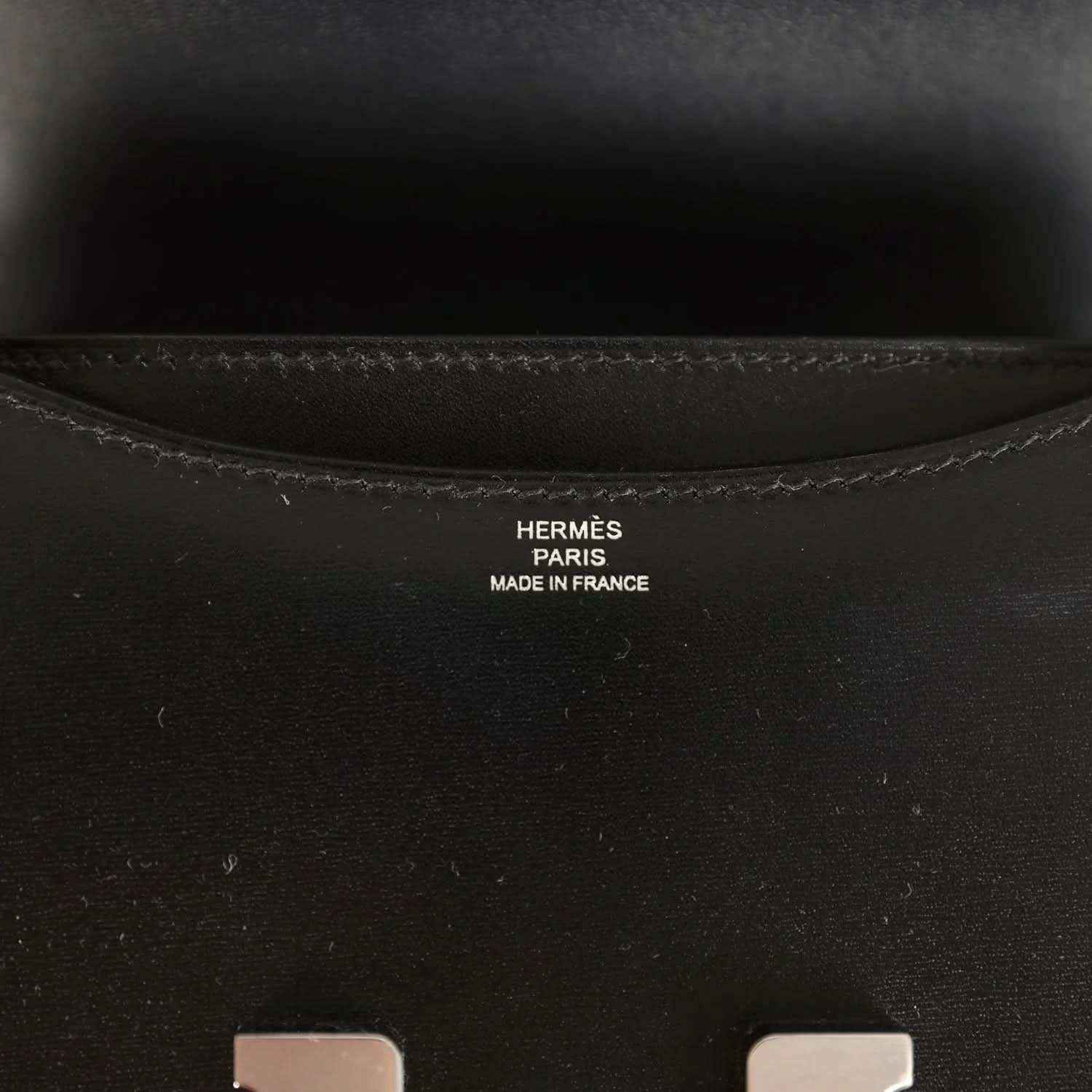 Hermes Paris made in France stamp inside black calfskin bag near seam stitching.