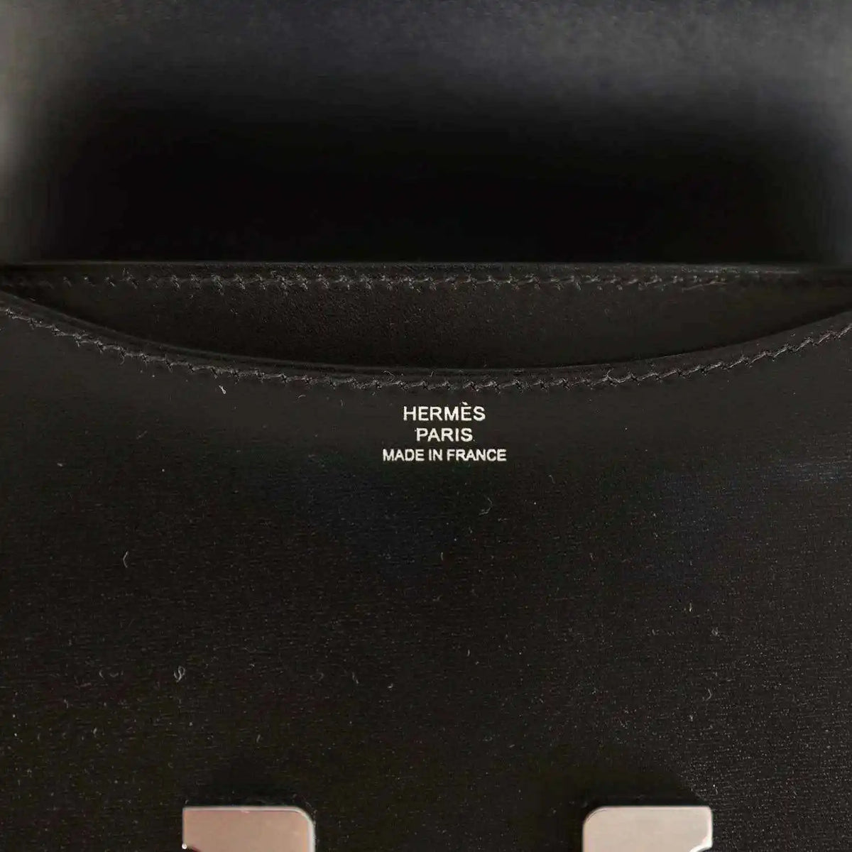 Hermes Paris made in France stamp inside black calfskin bag near seam stitching.