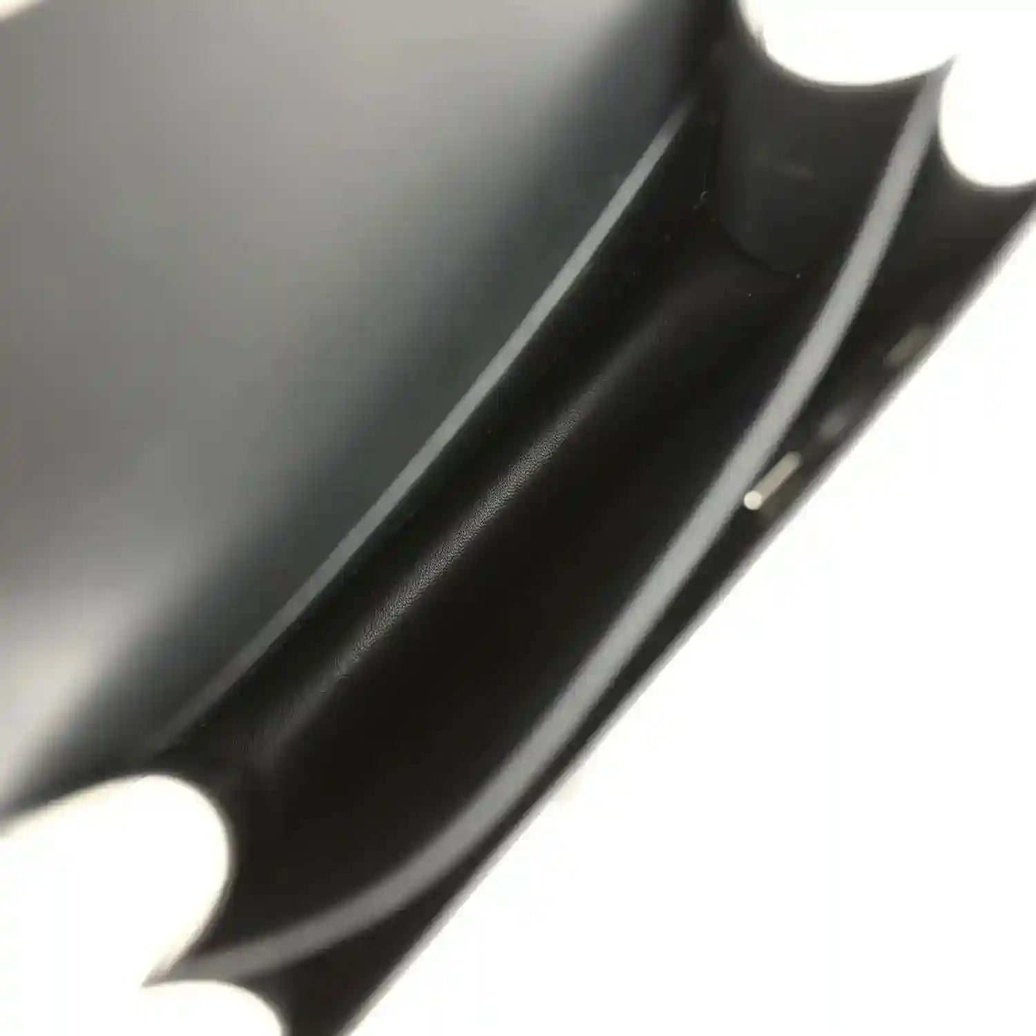 Black calfskin interior close-up with seam and edge trim.