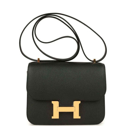 Black crossbody handbag with gold-tone H clasp and top flap, textured leather.