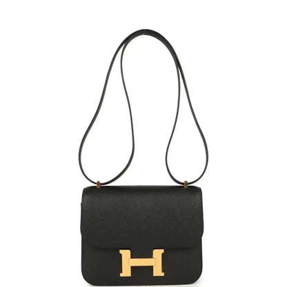 Black crossbody handbag with gold-tone H clasp, top flap, and long leather strap.