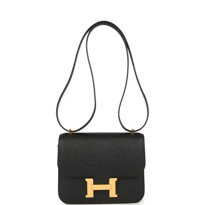 Black crossbody handbag with gold-tone H clasp, top flap, and long leather strap.