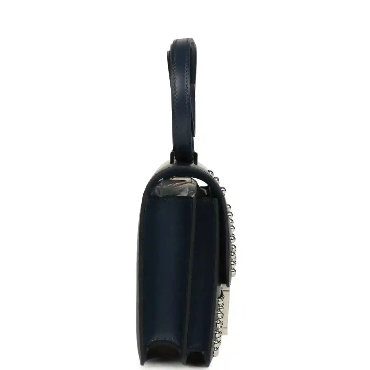 Blue leather crossbody bag with top handle, side view, and silver-tone chain detail