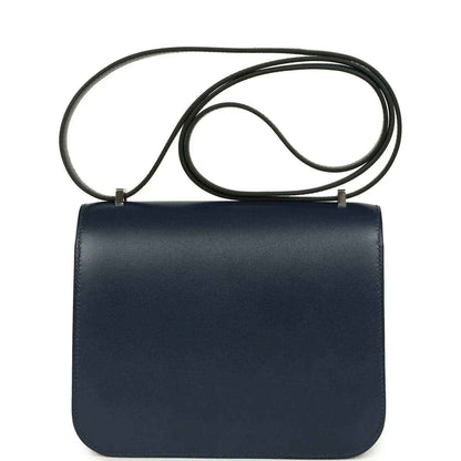 Navy-blue leather flap crossbody bag with long strap and no studded front