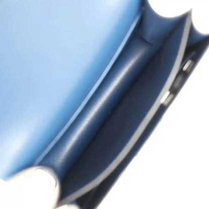 Blue leather lining and interior edge of a flap handbag with metal clasp
