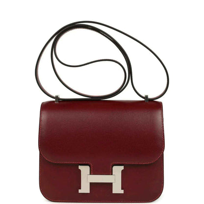 Burgundy leather crossbody bag with top handle and silver H clasp front.