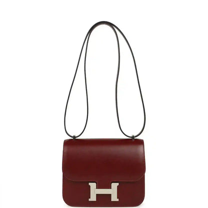 Burgundy leather crossbody bag with long strap and silver H clasp.