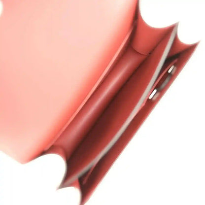 Burgundy leather bag interior detail with stitched edge and metal hardware.