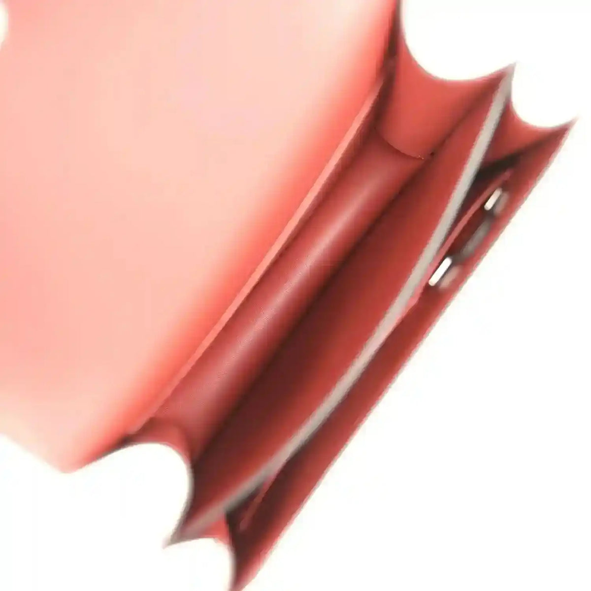 Burgundy leather bag interior detail with stitched edge and metal hardware.
