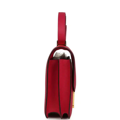 Red leather handbag with gold-tone hardware and side profile viewing
