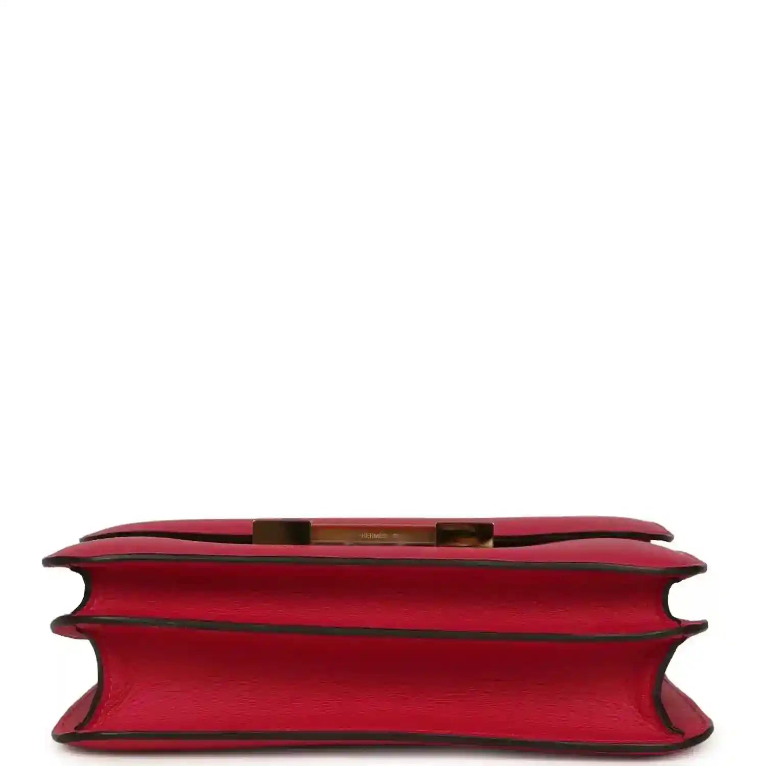 Red leather handbag underside view with side edges and gold-tone trim