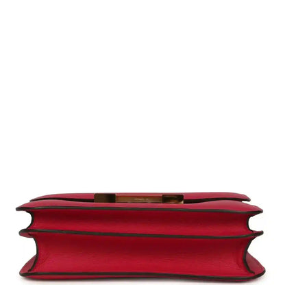 Red leather handbag underside view with side edges and gold-tone trim